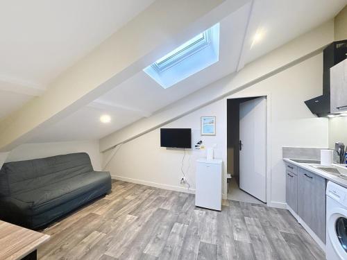 - un salon mansardé avec un canapé dans l'établissement Appartement tout neuf 4 pers N3, à Riom