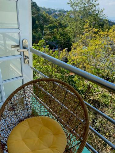 a rattan chair sitting on a balcony with a view at Hùng Nam House in Khu Chi Lăng