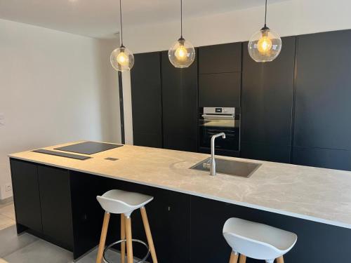 - une cuisine avec un évier et deux tabourets de bar dans l'établissement la maison Sapanomar, à Beaumes-de-Venise