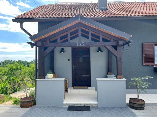a house with a wooden door with a roof at Vacation house SMEKI in Lokošin Dol