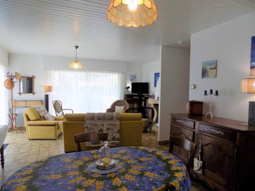 un salon avec une table et un canapé dans l'établissement La Palmyre - MAISON INDIVIDUELLE - au CALME - PROCHE FORET, à La Palmyre