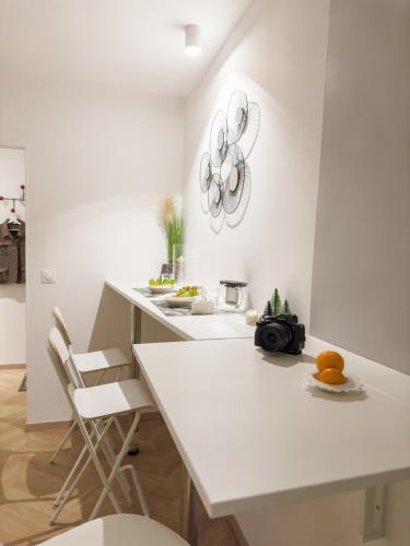 une cuisine avec un comptoir blanc et une table dans l'établissement - Chic - Calm - Designed - paris central, à Paris