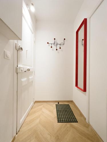 un couloir blanc avec un tapis noir et blanc sur le sol dans l'établissement - Chic - Calm - Designed - paris central, à Paris