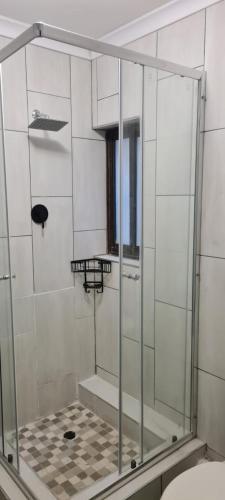 a shower with a glass door in a bathroom at Corona Del Mar 23 in Uvongo Beach