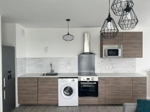 une cuisine avec une machine à laver et un évier dans l'établissement Logement Spacieux A 2 Chambres, Acces Facile Aeroport CDG et Paris, à Villiers-le-Bel
