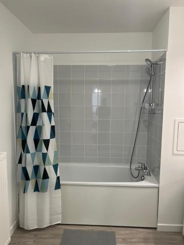 La salle de bains est pourvue d'une baignoire avec rideau de douche. dans l'établissement Logement Spacieux A 2 Chambres, Acces Facile Aeroport CDG et Paris, à Villiers-le-Bel