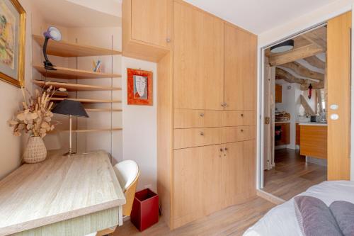 une chambre avec un lit et un bureau dans une pièce dans l'établissement Heart of Paris, Montorgueil, Charming Duplex, à Paris