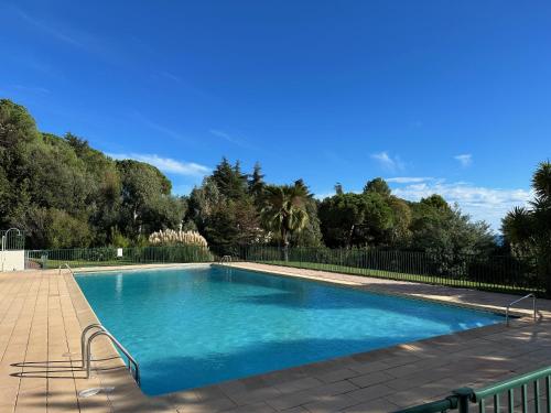 une grande piscine bleue avec des arbres en arrière-plan dans l'établissement Immogroom - Spacious bright T3 - Sea view -Terrace, à Cannes