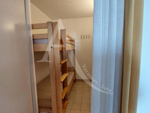 une petite chambre avec un escalier et un escalier. dans l'établissement Studio cabine 4 personnes vue jardin dans residence avec piscine, à Sète