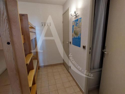 un couloir avec une porte menant à une salle de bains. dans l'établissement Studio cabine 4 personnes vue jardin dans residence avec piscine, à Sète