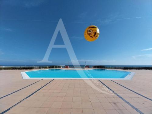 Une balle vole en l'air à côté d'une piscine dans l'établissement Studio cabine 4 personnes vue jardin dans residence avec piscine, à Sète