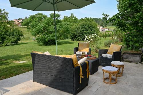 a group of chairs and an umbrella on a patio at La Petite Toscane en Beaujolais in Saint-Vérand
