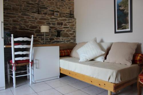- un canapé dans une chambre avec un mur en briques dans l'établissement Gite du Becquet, à Le Rozel