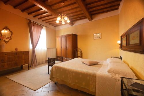 a bedroom with a bed and a dresser and a window at Fattoria Poggio Capponi in Montespertoli