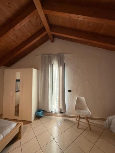 a bedroom with a bed and a chair and a window at Affittacamere Karma Rho-Fiera in Rho