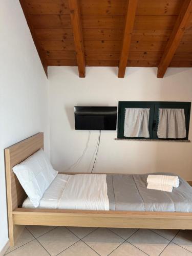 a bed in a room with two towels hanging on the wall at Affittacamere Karma Rho-Fiera in Rho