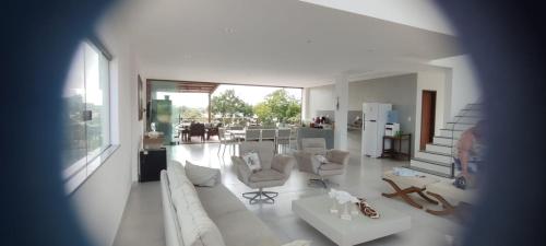 a living room with white furniture and a kitchen at Casa completa Porto Sauipe in Porto de Sauipe