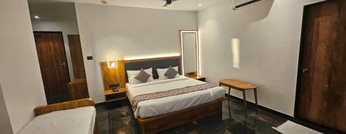 a hotel room with a bed and a chair at Vistara Residency in Navi Mumbai