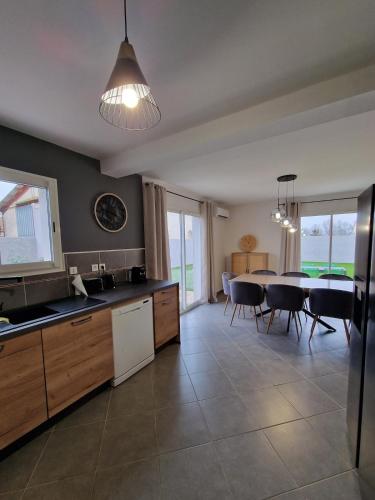 une cuisine et une salle à manger avec une table et des chaises dans l'établissement Villa avec piscine privée, à Sallèles-dʼAude