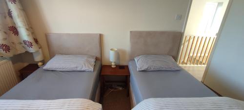 two twin beds in a room with a window at Sheffield Arena Meadowhall Interchange with off road free parking & CCTV in Sheffield