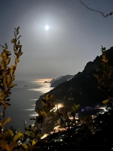 a view of the ocean at night with the moon at Colle dell'Ara in Positano