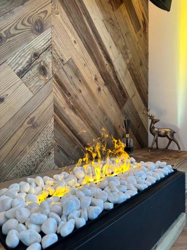 a table with a fire in front of a wooden wall at Zwierzyniecka Residence in Zakopane