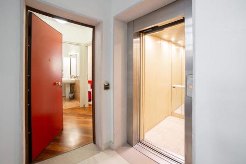 ein Flur mit einer roten Tür und einem Spiegel in der Unterkunft Venetian Dreams - Giudecca in Venedig