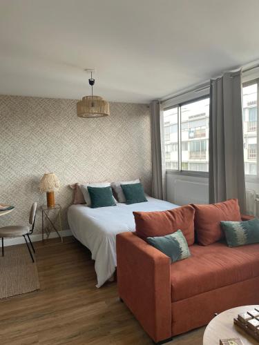 une chambre avec un grand lit et un canapé dans l'établissement Cozy apartment with parking and panoramic views!, à Amiens