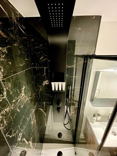 La salle de bains est pourvue d'un lavabo et d'une paroi en verre. dans l'établissement Cozy apartment with parking and panoramic views!, à Amiens