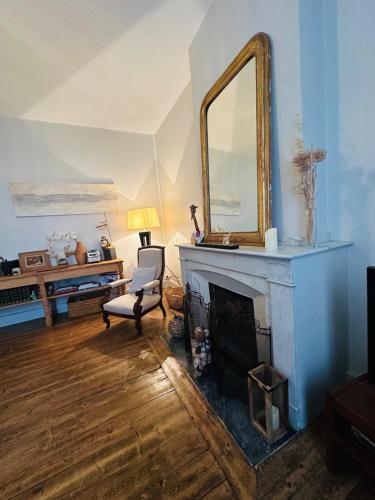 - un salon avec un miroir au-dessus d'une cheminée dans l'établissement La charmante maison de ville toute équipée, à Carcassonne