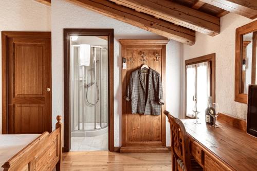 a room with a door with a suit hanging on it at Asolo Norah's Hill Agri Rooms in Caenere