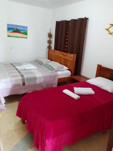 a room with two beds and a red blanket at Jangadas do Pontal in Fortim