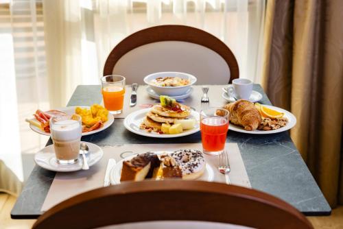 a breakfast table with plates of breakfast foods and drinks at Il Gentiluomo Hotel & SPA in Arezzo