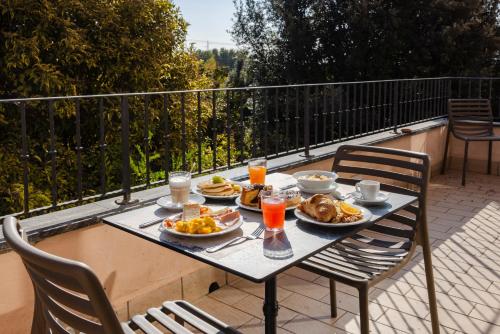 a table with plates of food and drinks on a balcony at Il Gentiluomo Hotel & SPA in Arezzo