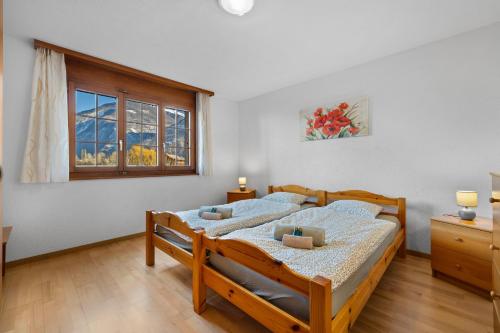 a bedroom with two beds and a window at Nid douillet aux bains de Saillon in Saillon