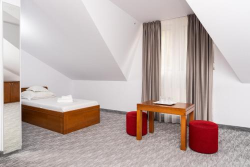 a bedroom with a bed and a desk and a table at Hotel Casa de Piatra in Scheia