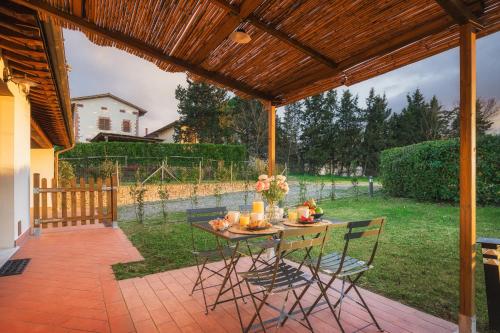 a patio with a table and chairs under a pergola at Casa d'Orcia in Pienza