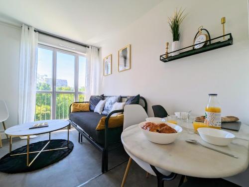 un salon avec une table et un canapé dans l'établissement Le Liberty - Joli T2 à Saint-Brieuc, à Saint-Brieuc