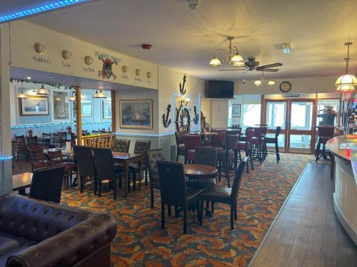 a dining room with tables and chairs in a restaurant at The Buccaneer Inn in Torquay