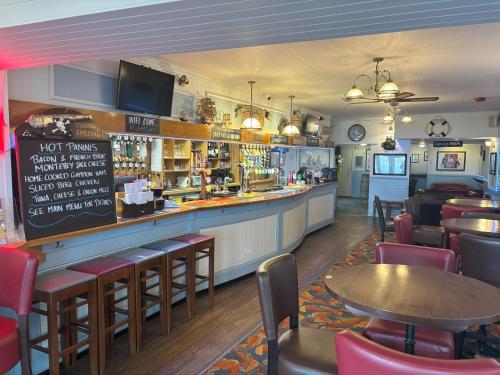 a restaurant with a bar with tables and chairs at The Buccaneer Inn in Torquay