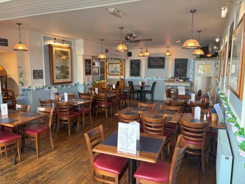 a dining room with wooden tables and chairs at The Buccaneer Inn in Torquay