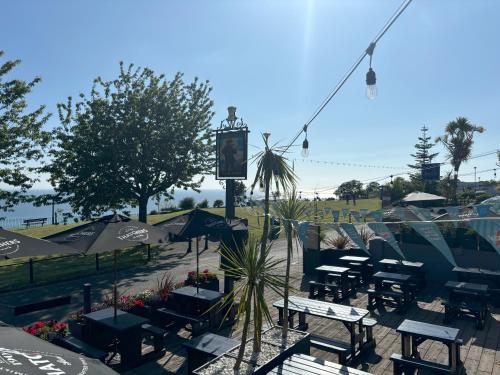 a patio with tables and chairs and umbrellas at The Buccaneer Inn in Torquay