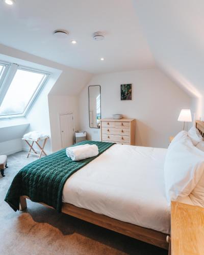 a bedroom with a large bed and a window at Forest Corner Luxury Home with Hot Tub in North Ballachulish