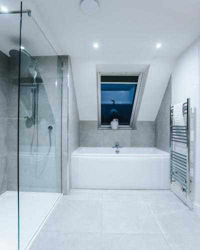 a bathroom with a bath tub and a window at Forest Corner Luxury Home with Hot Tub in North Ballachulish