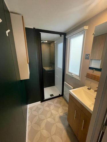 une salle de bain avec une douche, un lavabo et un miroir dans l'établissement Domaine de Kerlann 688, à Pont-Aven