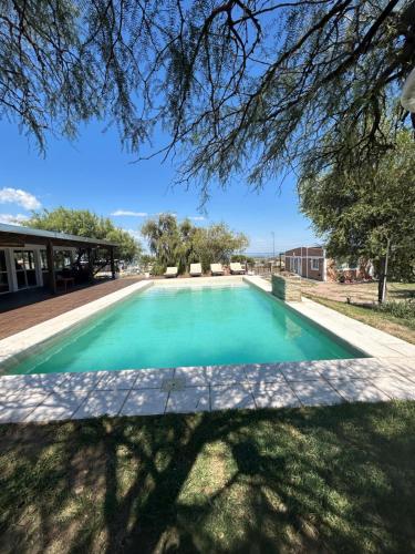 a swimming pool in a yard with a tree overhead at Complejo Puesta del Sol san Luis in La Punta