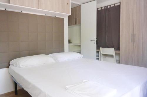 a bedroom with a large white bed in it at Camping Village Torre Pendente in Pisa