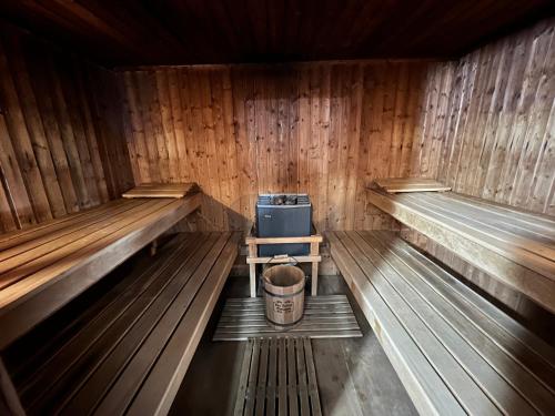 a small wooden sauna with a bucket in it at Hop Loft-Barn Conversion, with access to Pool & Hot Tub-at Fox Valley Cottages in Looe