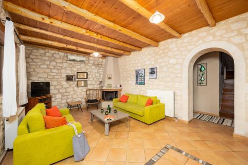 a living room with two yellow couches and a table at Villa Hara Faragi in Giannoudi
