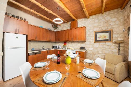 a kitchen with a wooden table and a white refrigerator at Villa Hara Faragi in Giannoudi